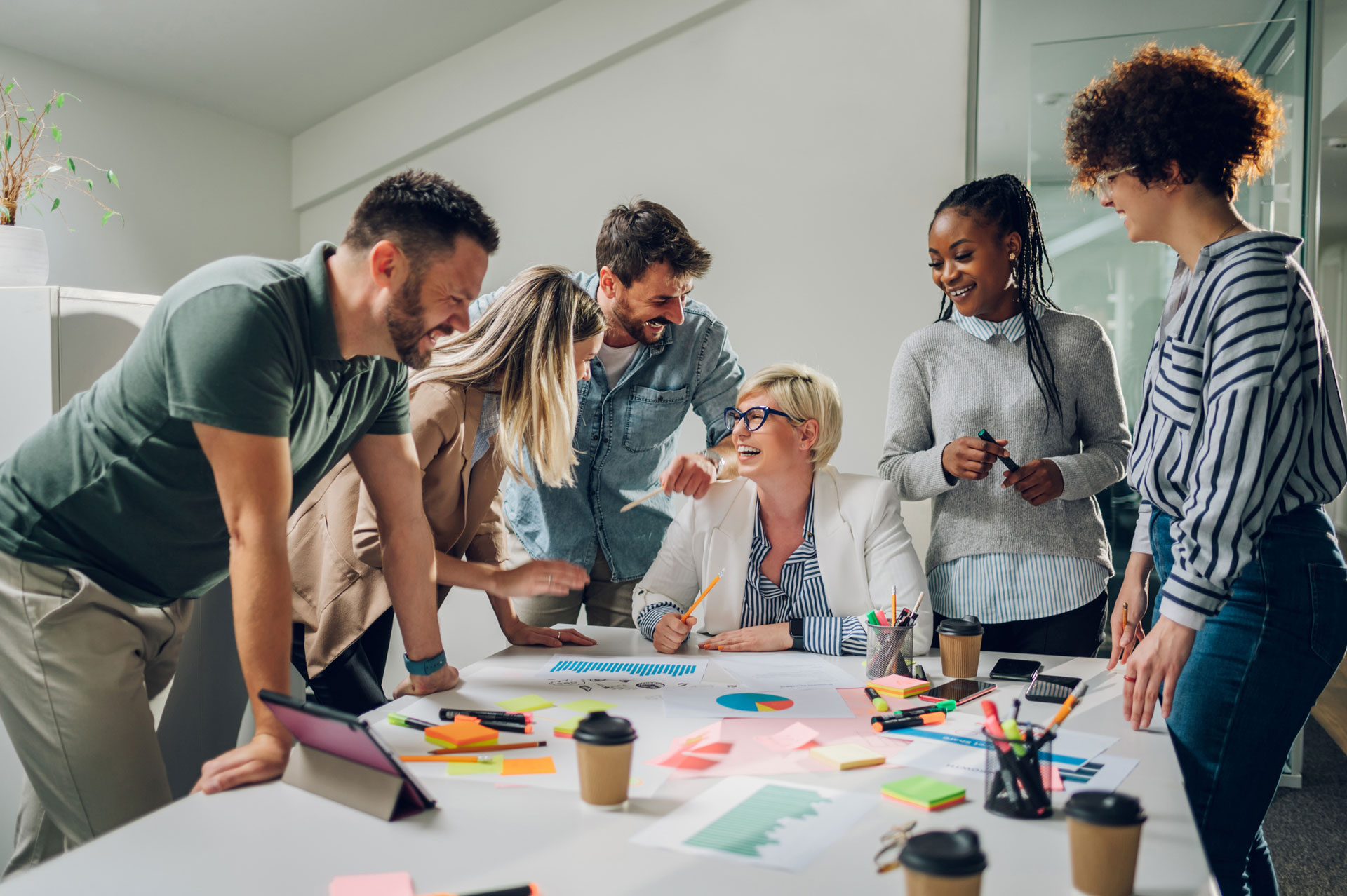 Gestion de projet et gestion des risques Six personnes discutant d'un projet autour d'un bureau de travail, séance de brainstorm.